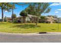 Single-story home with red door, landscaping, and driveway at 2215 Se 24Th Ave, Ocala, FL 34471