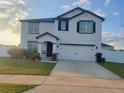 Two story home with white siding, dark trim, and a two car garage at 4551 Ne 27Th St, Ocala, FL 34470