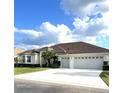One-story house featuring a three-car garage and a well-maintained lawn at 5858 Nw 27Th Pl, Ocala, FL 34482