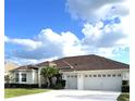 Spacious house with a three-car garage, palm trees, and well-manicured lawn at 5858 Nw 27Th Pl, Ocala, FL 34482