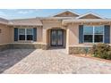 House exterior features a paver driveway and a two-car garage at 8445 Sw 93Rd Cir, Ocala, FL 34481