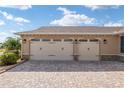 Three-car garage with paver driveway and stone accents at 8445 Sw 93Rd Cir, Ocala, FL 34481