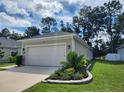 Tan house with two car garage and nicely landscaped yard at 7867 Sw 74Th Loop, Ocala, FL 34481