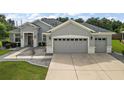 Gray two-story house with two-car garage and landscaped yard at 13944 Se 96Th Cir, Summerfield, FL 34491