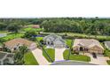 Aerial view of a house with a large driveway and surrounding homes at 13944 Se 96Th Cir, Summerfield, FL 34491