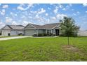 Single-story house, green exterior, two-car garage, and grassy yard at 4978 Sw 91St St, Ocala, FL 34476