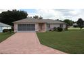 Brick driveway leading to a single-story house with a screened-in garage at 10293 Sw 61St Terrace Rd, Ocala, FL 34476