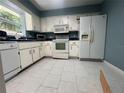 Bright kitchen featuring white cabinets and tiled floors at 4628 Ne 8Th Pl, Ocala, FL 34470