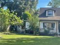 View of a charming white house with a large yard and side shed at 5120 Se 145Th St, Summerfield, FL 34491