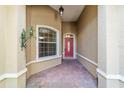 Front entry with a red door and terracotta tile flooring at 8650 Sw 83Rd Loop, Ocala, FL 34481