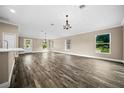 Spacious living room with wood-look flooring and a chandelier at 706 Stanley Ave, Wildwood, FL 34785
