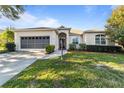 Single story house exterior featuring a two-car garage and landscaping at 9580 Sw 90Th St, Ocala, FL 34481