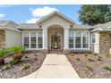 Elegant home exterior with stone accents and a landscaped walkway at 8280 Se 15Th Ct, Ocala, FL 34480