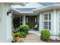 Inviting front entrance with a green door, rocking chair, and lush landscaping at 15235 Sw 14Th Avenue Rd, Ocala, FL 34473