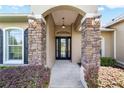 Covered entry with stone pillars and a stylish front door at 4321 Se 40Th Ln, Ocala, FL 34480