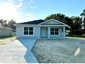 Newly built gray house with a driveway at 10816 Se 66Th Ave, Belleview, FL 34420