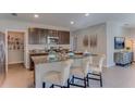 Spacious kitchen with dark cabinets, granite counters, and island at 3184 Evenmore Way, Wildwood, FL 34785