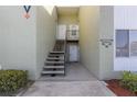 Exterior view of a light-green building with stairs leading to individual condo units at 551 Fairways Dr # A, Ocala, FL 34472