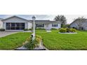 White single story home with a landscaped lawn and screened porch at 17587 Se 95Th Cir, Summerfield, FL 34491