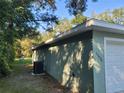 Side view of a newly built home showcasing its light green exterior and garage at 13921 Sw 108Th Ln, Dunnellon, FL 34432