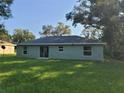 Rear view of a newly built home with a large backyard at 13921 Sw 108Th Ln, Dunnellon, FL 34432