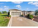 Two-car garage with a driveway featuring a geometric design and landscaping at 9766 Sw 90Th St, Ocala, FL 34481