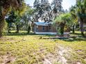 Cute brown house with metal roof, surrounded by lush landscaping at 12146 E Highway 318, Fort Mc Coy, FL 32134