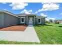 Gray house exterior with a walkway and nicely landscaped front yard at 7570 Sw 100Th St, Ocala, FL 34476