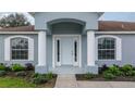 Inviting front entrance with a light grey door and white columns at 4504 Sw 106Th Pl, Ocala, FL 34476