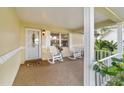 Relaxing front porch with white rocking chairs and a view of the landscape at 9257 Sw 82Nd Ter # H, Ocala, FL 34481