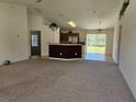 Spacious living room with carpeting and access to kitchen at 14984 Sw 28Th Terrace Rd, Ocala, FL 34473