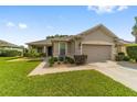 Tan one-story home with attached garage and manicured lawn at 7335 Sw 97Th Terrace Rd, Ocala, FL 34481