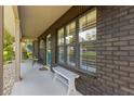 Front porch with white bench and teal door at 5906 Sw 108Th St, Ocala, FL 34476