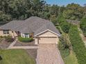 Aerial view of a single-story house with a paved driveway and landscaped yard at 13166 Se 86Th Cir, Summerfield, FL 34491