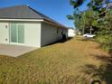 View of the house's side, showing a large grassy yard at 19 Cedar Dr, Ocala, FL 34472
