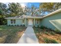 Front view of a charming house featuring a walkway and landscaping at 19662 Sw Marine Blvd, Dunnellon, FL 34431