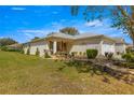 Tan house with stone landscaping, two-car garage, and porch at 9815 Sw 92Nd Place Rd, Ocala, FL 34481