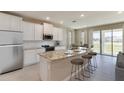 Open kitchen features granite island, stainless steel appliances & view to backyard at 9317 Sw 60Th Court Rd, Ocala, FL 34476