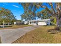 Front view of house with driveway and mature trees at 11205 Sw 63Rd Terrace Rd, Ocala, FL 34476
