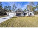 One-story home with gray siding, stone accents, and a grassy yard at 8285 Sw 129Th Terrace Rd, Dunnellon, FL 34432