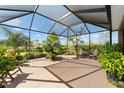 Spacious screened porch with patio furniture and lush tropical plants at 10584 Sw 91St Street Rd, Ocala, FL 34481