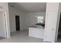 Open concept kitchen with island, white cabinets, and light grey flooring at 594 Nw Redwing Rd, Dunnellon, FL 34431