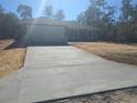 Newly built house with gray siding, white garage door, and a concrete driveway at 8 Malauka Pass Pl, Ocklawaha, FL 32179