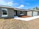 Newly built home with gray siding, attached garage, and small landscaped area at 35 Guava Terrace Radl, Ocklawaha, FL 32179