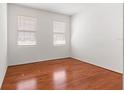 Simple bedroom with hardwood floors and two windows with blinds at 6175 Sw 88Th Loop, Ocala, FL 34476