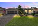 Inviting single story home with landscaped yard, illuminated at dusk at 17902 Se 115Th Cir, Summerfield, FL 34491