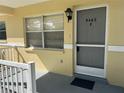 Front door entrance with a storm door and small porch at 9460 Sw 84Th Ter # E, Ocala, FL 34481