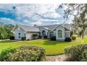 One-story home with a large front yard and mature landscaping at 7660 Nw 46Th Pl, Ocala, FL 34482