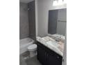 Updated bathroom with gray tile, granite vanity, and a bathtub at 157 Fisher Ct, Ocklawaha, FL 32179