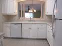 Bright kitchen with white cabinets, and a view to another room at 13644 Sw 115Th Ave, Dunnellon, FL 34432